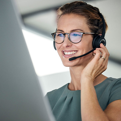 woman wearing headset smiling while using computer high quality customer service 5 essential tips